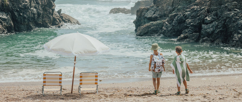 Two kids on the beach wearing CryWolf clothing walking towards the sea.