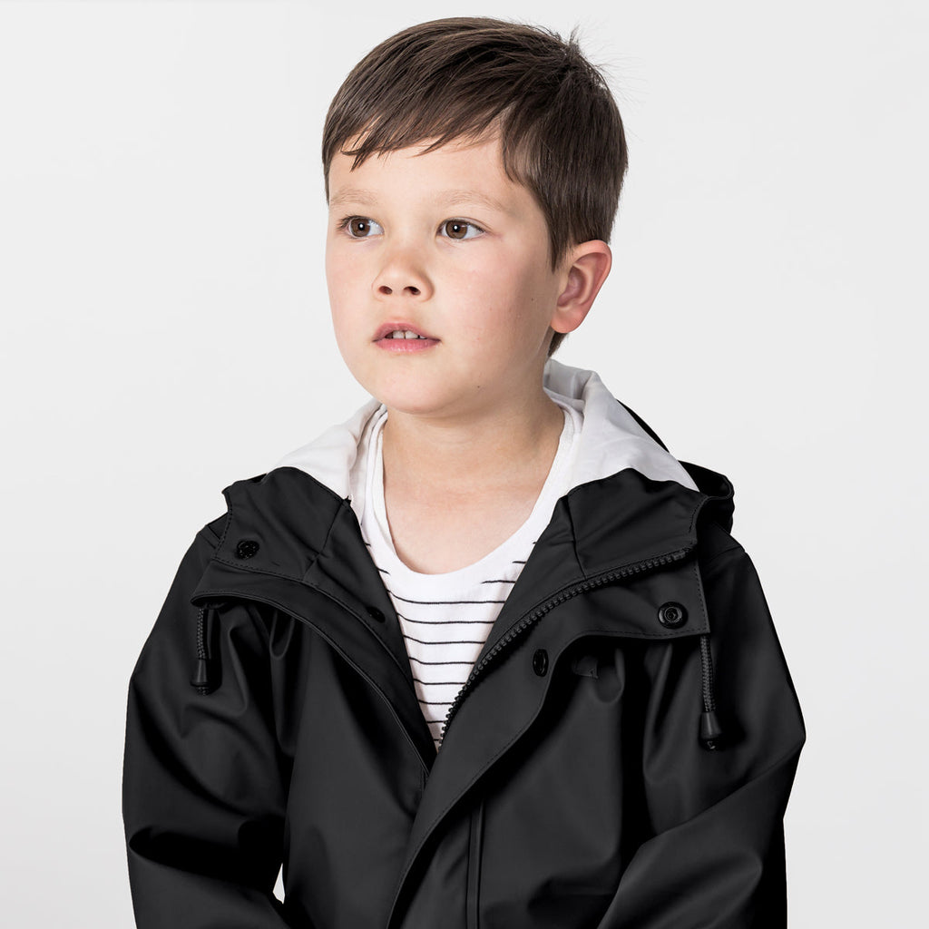 A Boy Wearing A Crywolf Classic Waterproof Play Jacket 
